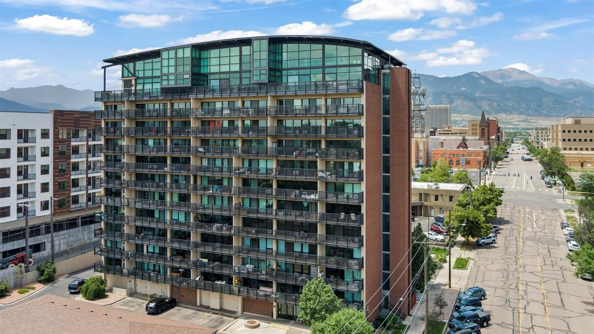 Citywalk’s residential tower and glass penthouse crown with the Front Range beyond downtown Colorado Springs