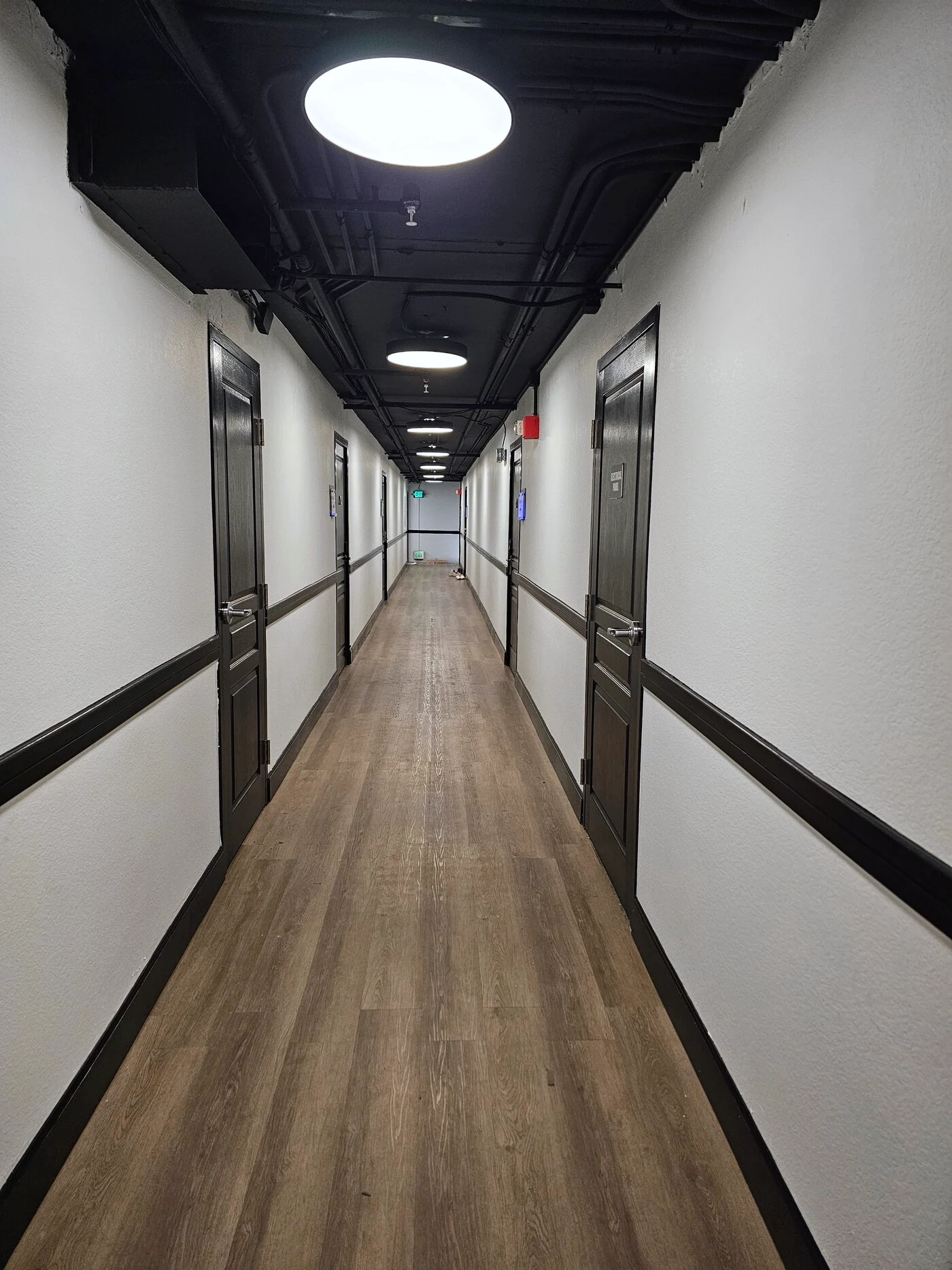 Completed fourth-floor hallway at Citywalk with updated lighting, flooring and black trim