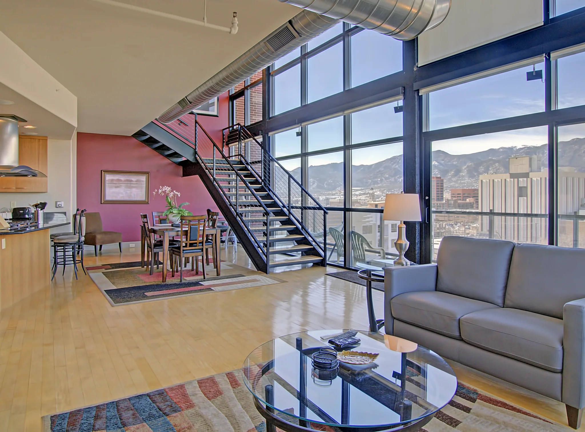 Penthouse 1206 with a steel staircase, double-height windows and mountain outlook