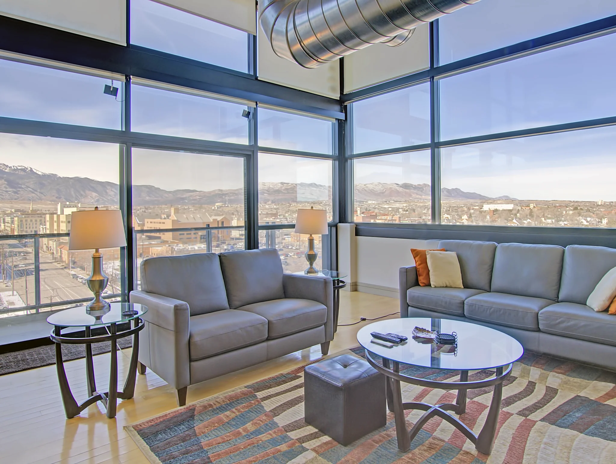 Corner living area in penthouse 1206 with mountain views through tall windows