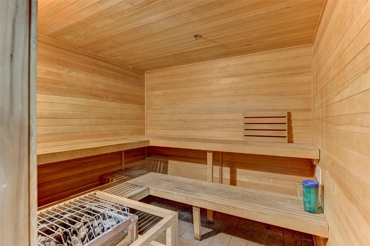 Citywalk shared sauna with wood-lined walls, tiered benches and a stone heater